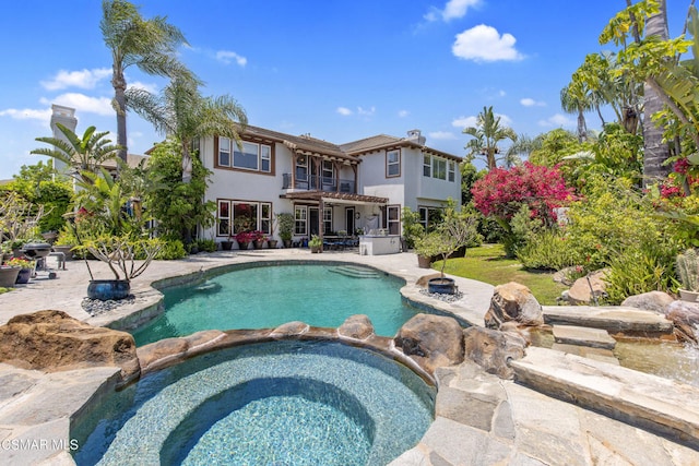 view of pool with a patio area and an in ground hot tub