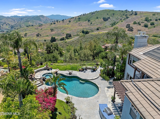 view of swimming pool with a patio and a mountain view