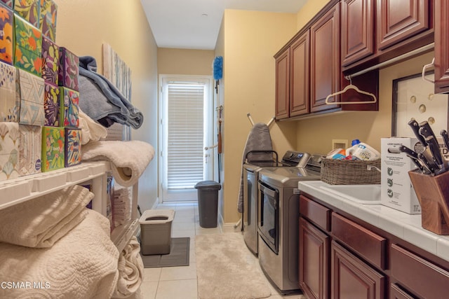 laundry area with cabinets, light tile patterned flooring, and washer and dryer