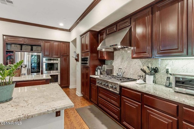 kitchen featuring light stone counters, stainless steel appliances, light hardwood / wood-style floors, decorative backsplash, and wall chimney range hood