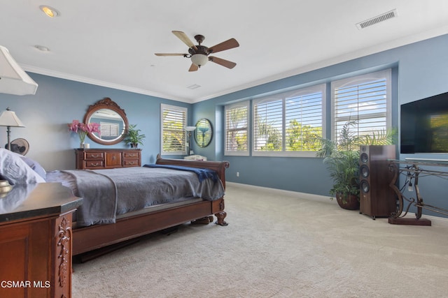 carpeted bedroom with ornamental molding and ceiling fan