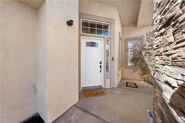 doorway to property featuring stucco siding