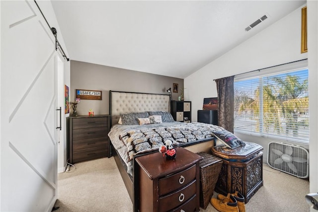 bedroom featuring lofted ceiling, a barn door, visible vents, and light colored carpet