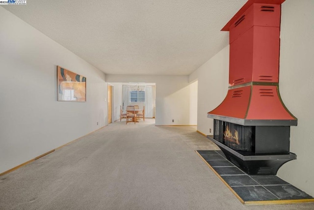 unfurnished living room with dark carpet and a textured ceiling