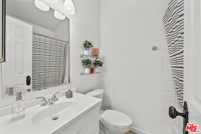 bathroom featuring vanity, a shower with curtain, and toilet