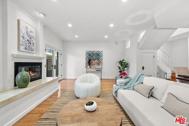 living room with ornamental molding and light wood-type flooring