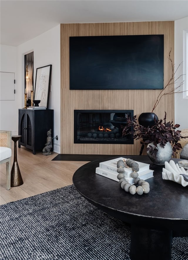 living area with a large fireplace and wood finished floors