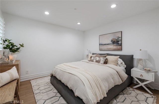 bedroom with baseboards, light wood-type flooring, and recessed lighting