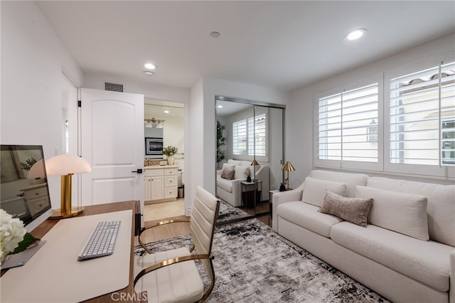 living room with light wood-style floors, recessed lighting, and visible vents