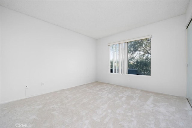 unfurnished room with light colored carpet