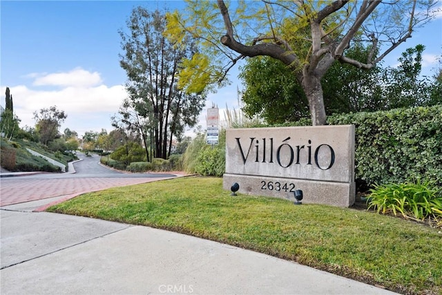 community / neighborhood sign featuring a lawn