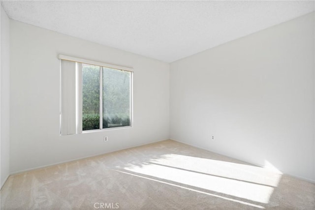 unfurnished room with light carpet and a textured ceiling