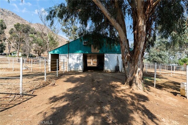 view of outbuilding with a rural view and a mountain view