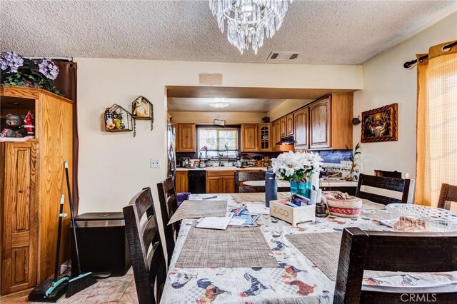 dining area with an inviting chandelier and a textured ceiling