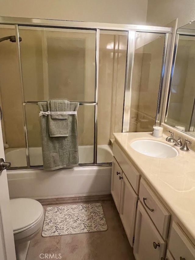 full bathroom featuring bath / shower combo with glass door, vanity, and toilet