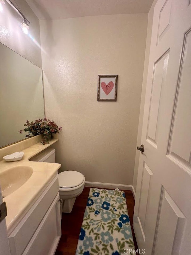 bathroom with vanity, hardwood / wood-style floors, and toilet