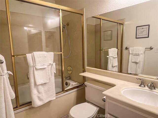 full bathroom featuring vanity, toilet, and combined bath / shower with glass door