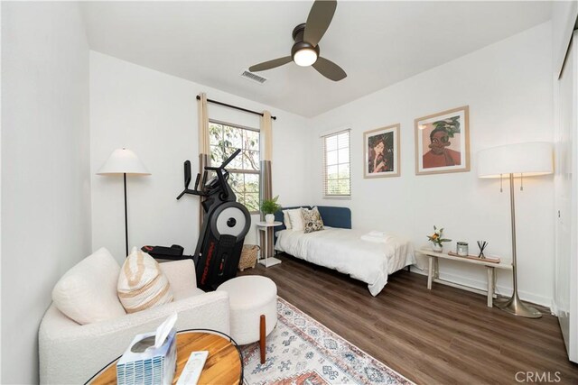 bedroom with dark hardwood / wood-style flooring and ceiling fan