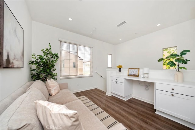 office space with built in desk and dark hardwood / wood-style flooring