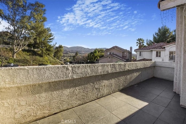 view of patio with a balcony and a mountain view