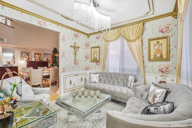 living room with an inviting chandelier and ornamental molding