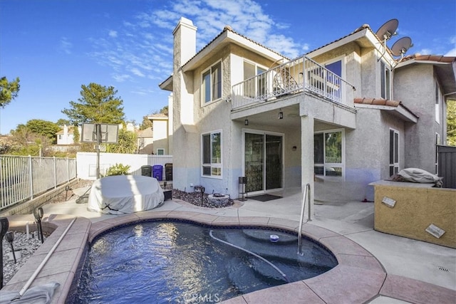 rear view of property with a patio and a balcony