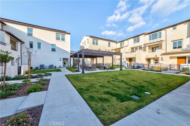 view of property's community with a pergola, a patio area, and a lawn