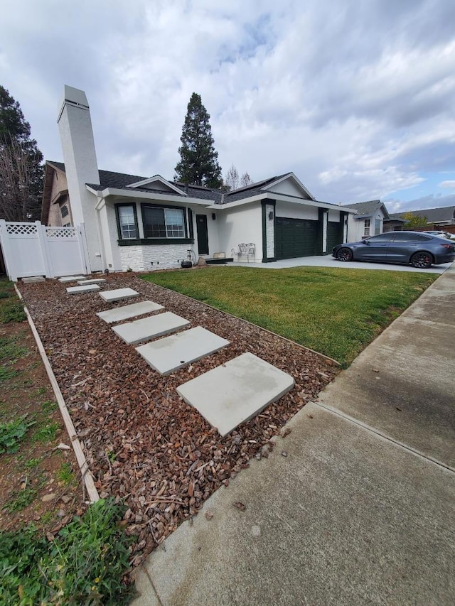 ranch-style house featuring a garage and a front lawn