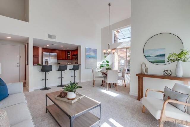 carpeted living room featuring a high ceiling and a notable chandelier