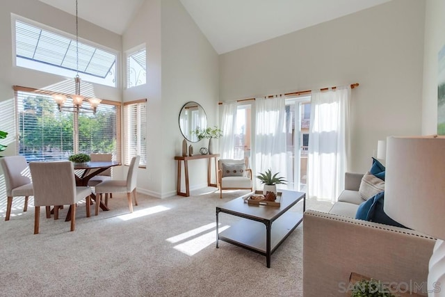 living room featuring high vaulted ceiling, light carpet, and a chandelier