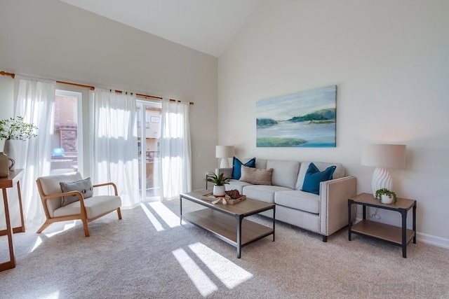 carpeted living room with high vaulted ceiling