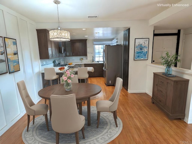 dining area with sink and light wood-type flooring