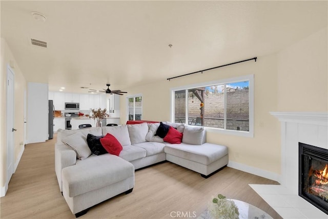 living room featuring ceiling fan and light hardwood / wood-style flooring