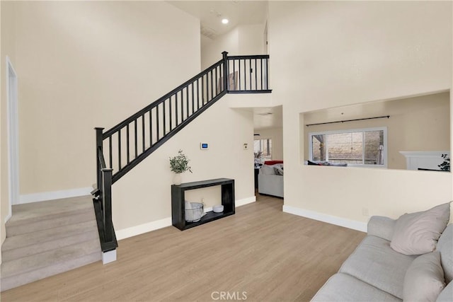 living room featuring a high ceiling and light wood-type flooring