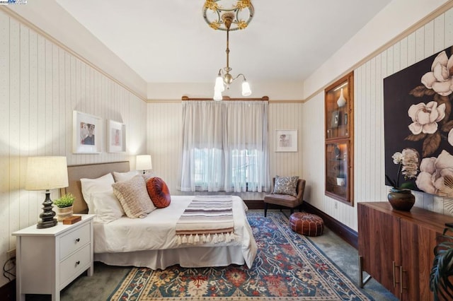 bedroom featuring a notable chandelier and dark carpet