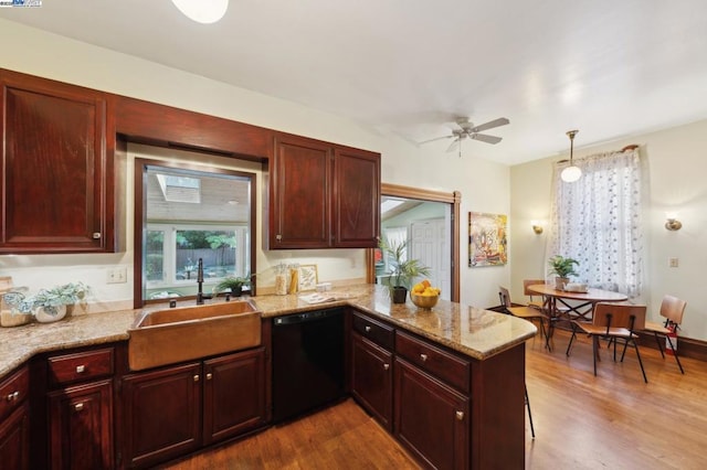 kitchen with sink, hanging light fixtures, kitchen peninsula, dishwasher, and hardwood / wood-style flooring