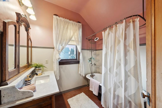 bathroom featuring shower / tub combo, vanity, and vaulted ceiling