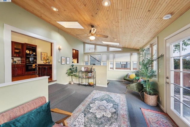 sunroom / solarium featuring ceiling fan, lofted ceiling with skylight, and wooden ceiling