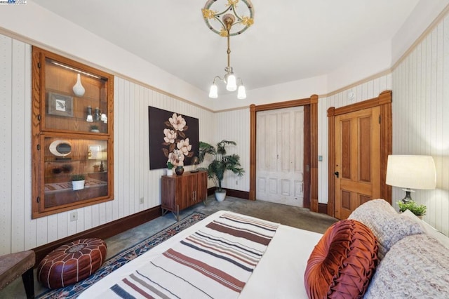 bedroom featuring a chandelier and dark colored carpet