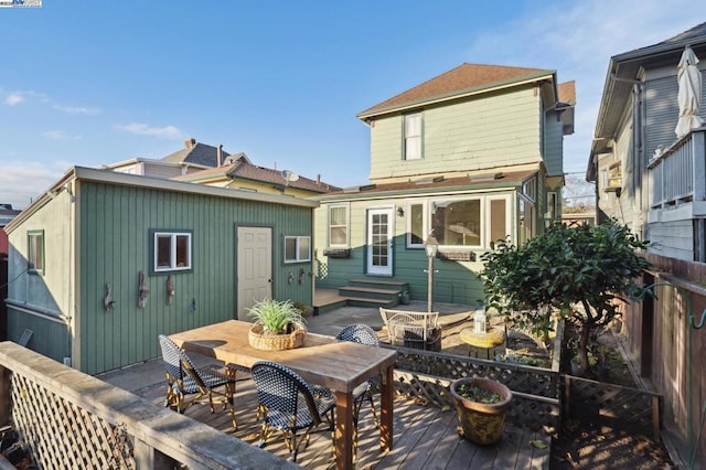 rear view of house featuring a wooden deck