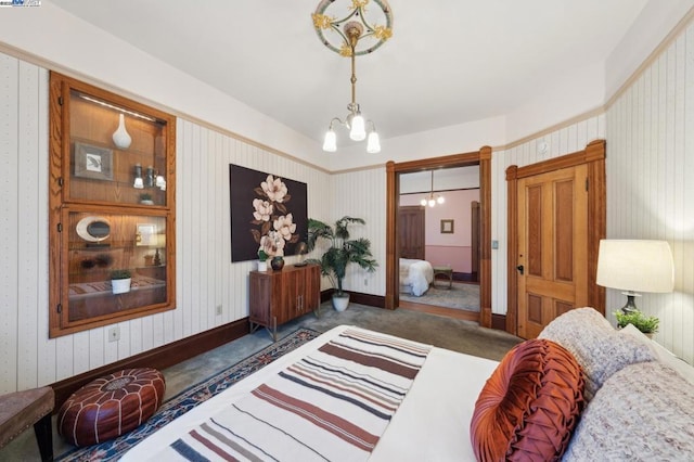 bedroom featuring a notable chandelier and dark carpet