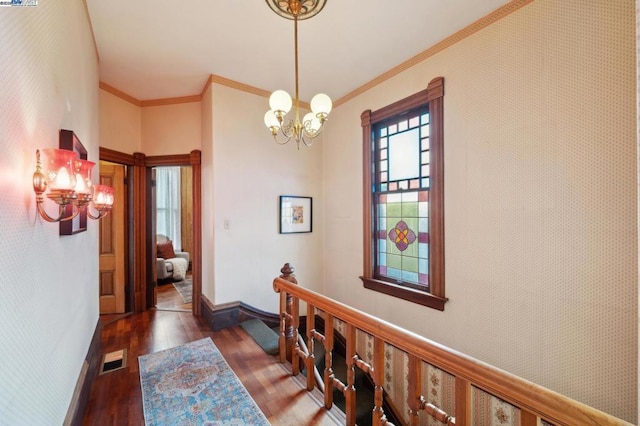 hallway featuring dark wood-type flooring, crown molding, and a chandelier