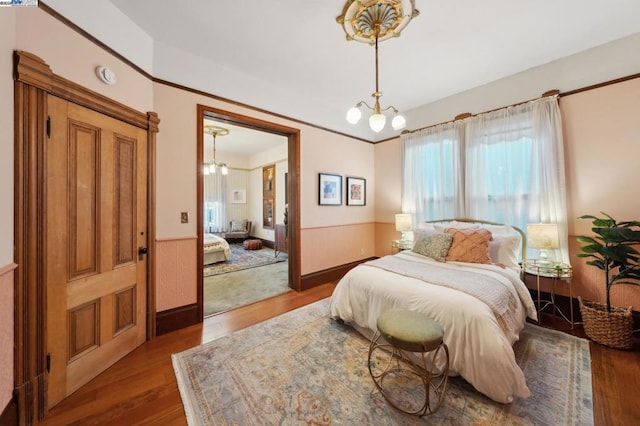 bedroom featuring hardwood / wood-style flooring and a chandelier