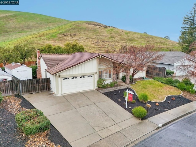 view of front of property featuring a garage, a mountain view, and a front lawn