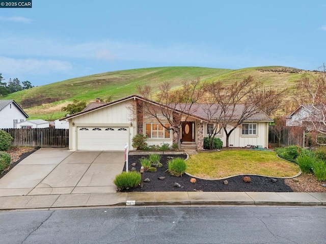 single story home featuring a mountain view, a garage, and a front lawn