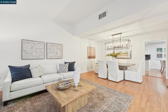 living room with wood-type flooring and an inviting chandelier