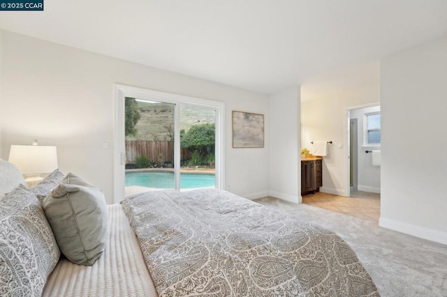 carpeted bedroom featuring access to exterior and ensuite bath