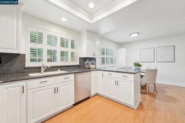 kitchen with sink, light wood-type flooring, dishwasher, kitchen peninsula, and white cabinets