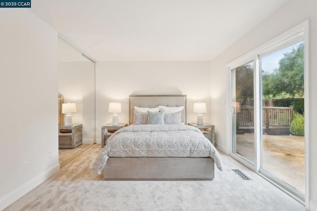 bedroom featuring access to exterior and light colored carpet