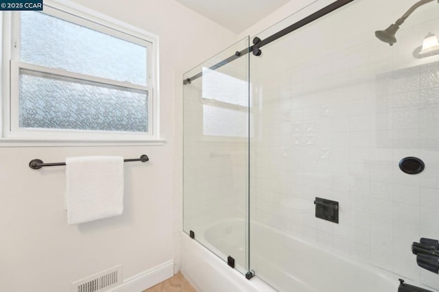 bathroom with combined bath / shower with glass door